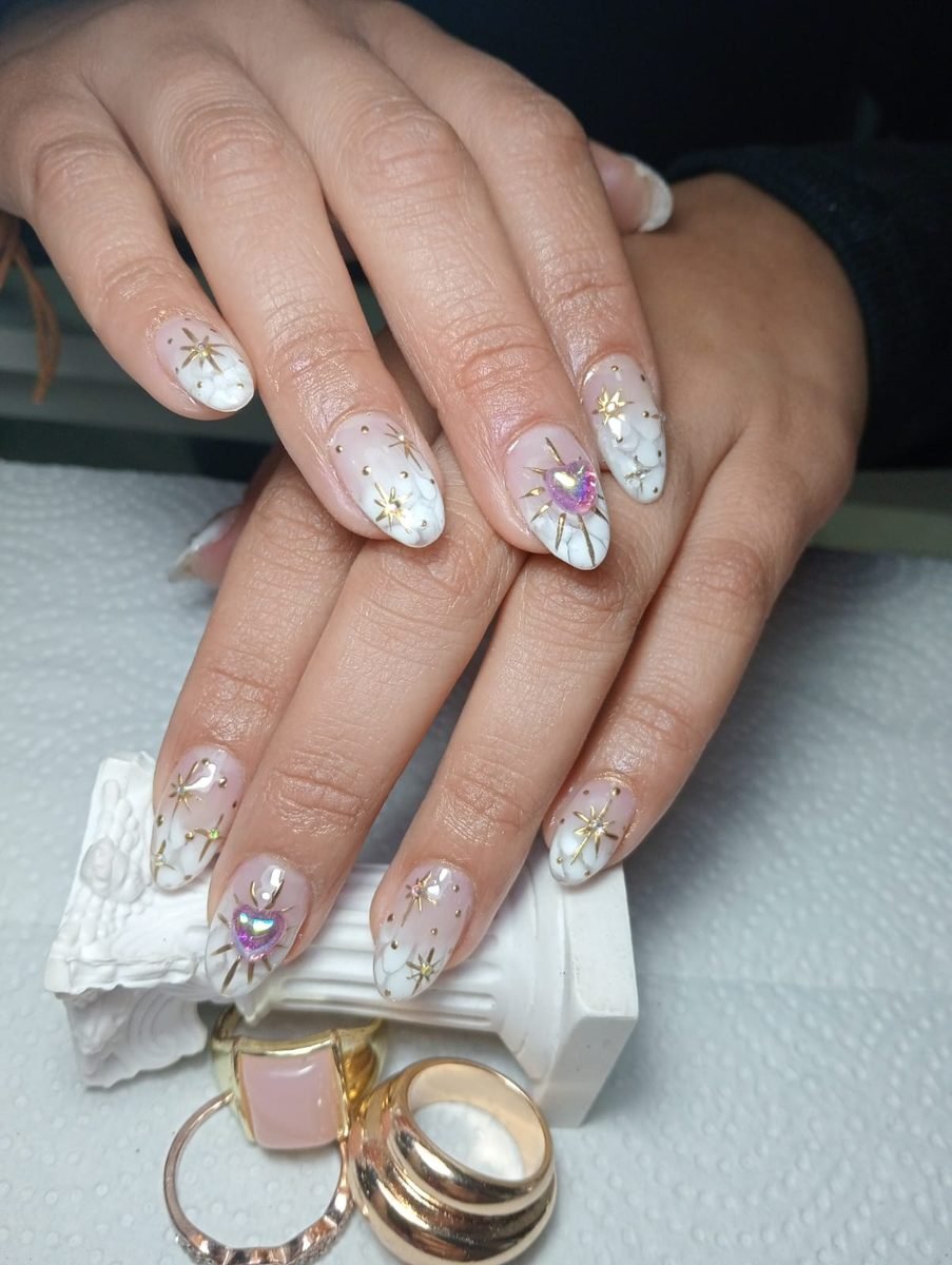 Uñas blancas con estrellas doradas y cristales